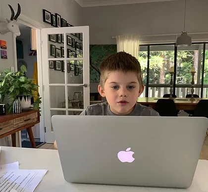 A boy looking at a laptop