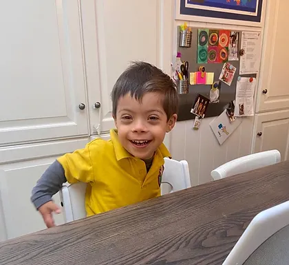 A boy sitting at a table smiling